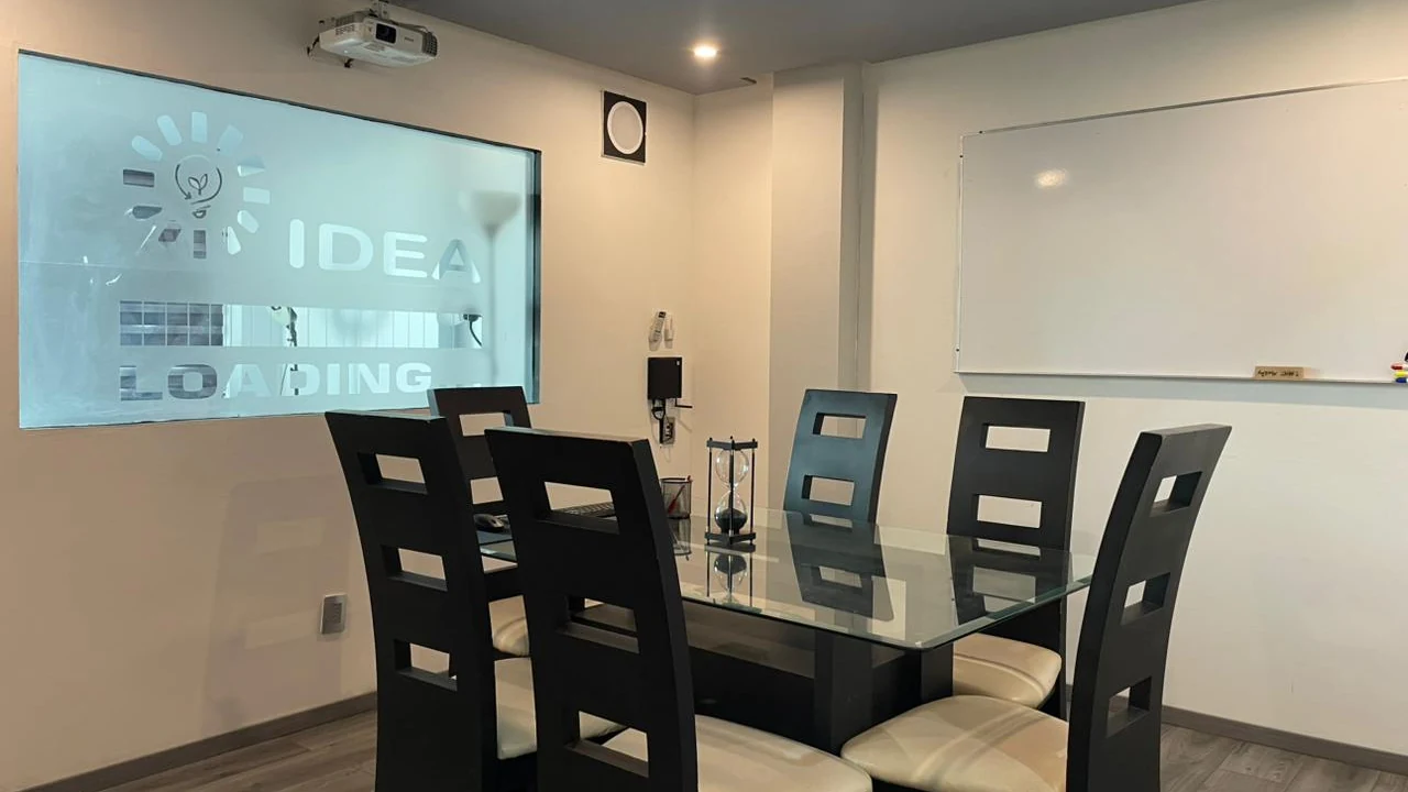Sala 1 con mesa ejecutiva y proyección